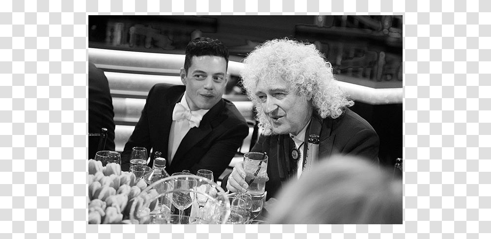Rami Malek And Queens Guitarist Brian May Photograph, Person, Glass, Sitting, Beverage Transparent Png
